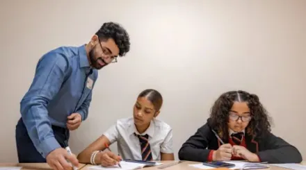 a male tutor with a beard and glasses with two year 9 girls