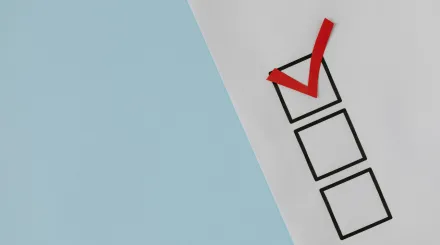 three checkboxes on a piece of paper, one is ticked with a red tick