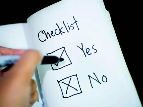 a notebook with a hand marking a checkbox yes with a tick and a cross for a no